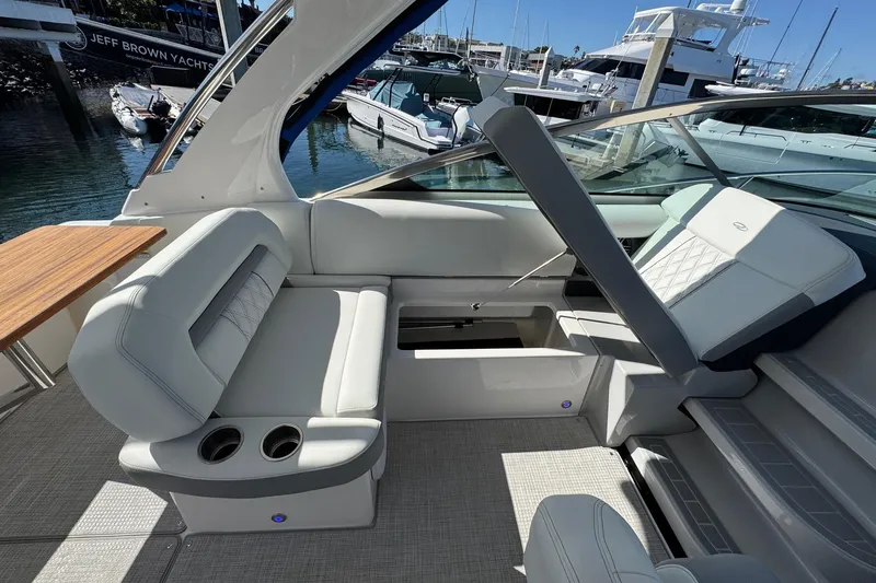 Slide: The Image of 2026 Regal 33 XO yacht interior with luxurious seating and cup holders, docked at marina. - 46