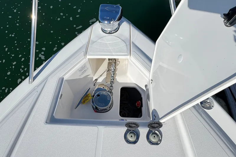 Slide: The Image of 2026 Regal 33 XO boat anchor compartment with chain and winch, open hatch view. - 68