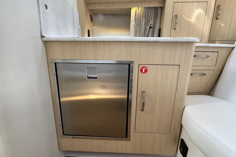 Slide: The Image of 2026 Regal 33 XO yacht interior with modern cabinetry and stainless steel fridge. - 87