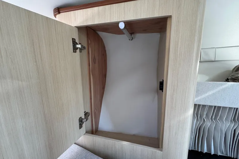 Slide: The Image of Open wooden cabinet inside 2026 Regal 33 XO boat interior. - 96