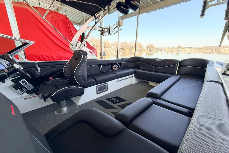 Slide: The Image of 2020 MasterCraft XT25 boat interior with black seating and lake view. - 25