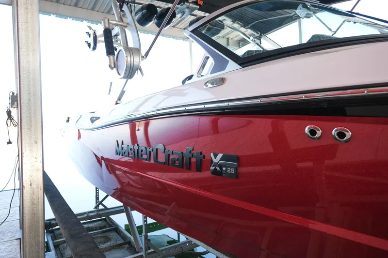 Slide: The Image of 2020 MasterCraft XT25 boat in red, docked under a covered structure. - 27