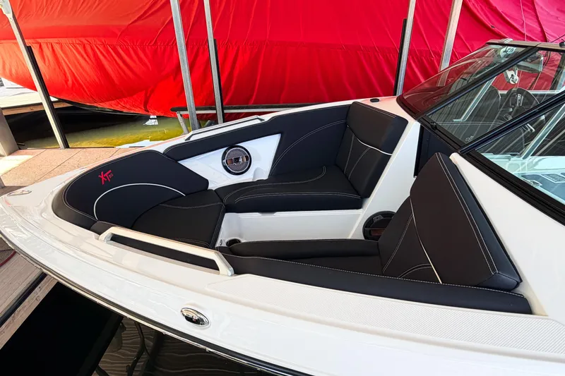 Slide: The Image of 2020 MasterCraft XT25 boat interior with black seating and red cover in background. - 28