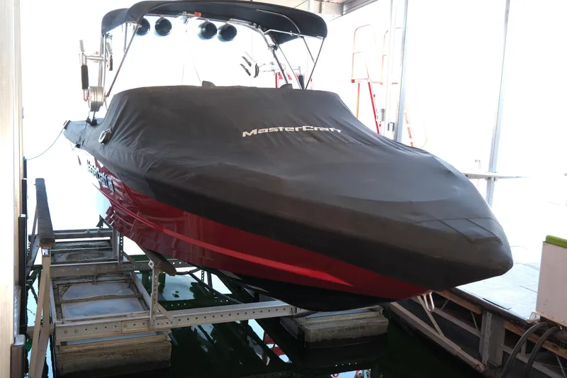 Slide: The Image of 2020 MasterCraft XT25 boat with cover on lift in storage. - 30