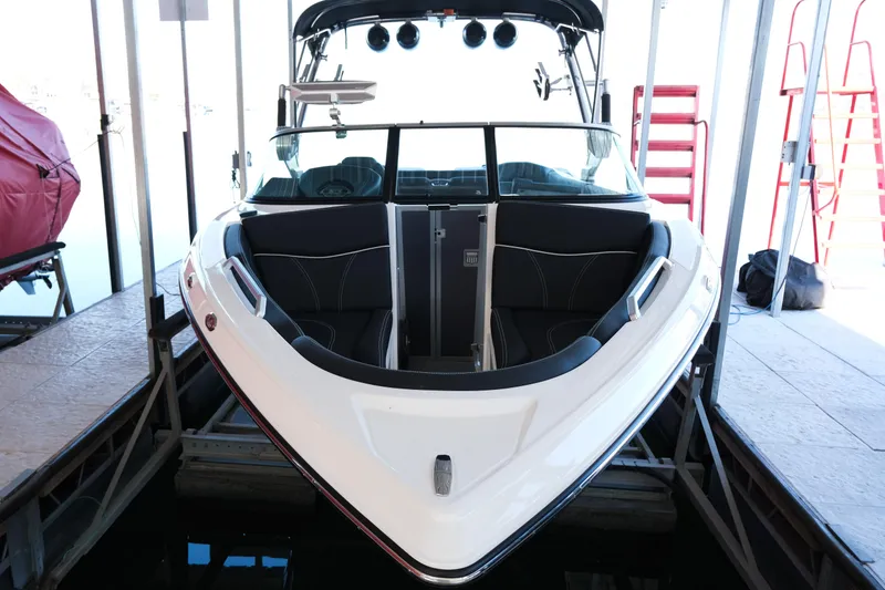 Slide: The Image of 2020 MasterCraft XT25 boat docked, showcasing sleek design and spacious seating. - 32