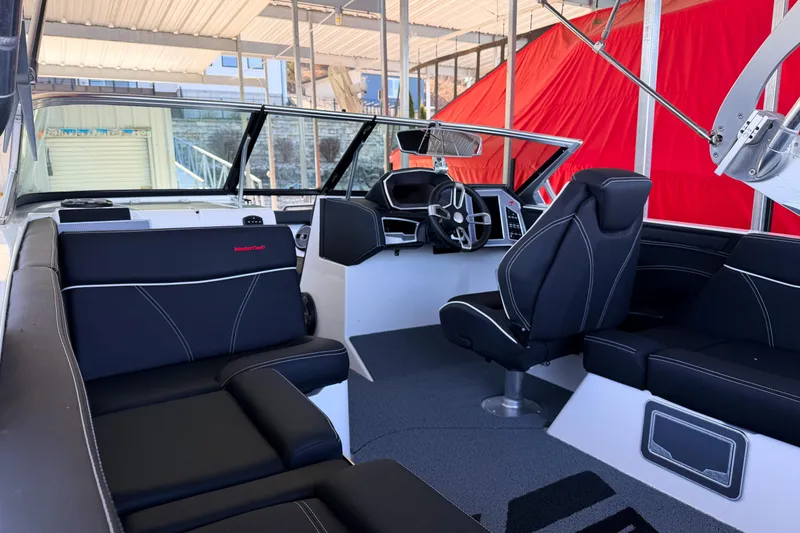 Slide: The Image of 2020 MasterCraft XT25 boat interior with black seating and modern dashboard. - 35