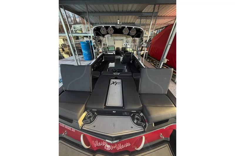 Slide: The Image of 2020 MasterCraft XT25 boat interior with seating and storage, docked under a canopy. - 36