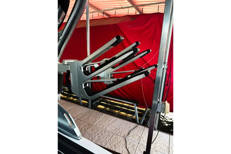Slide: The Image of 2020 MasterCraft XT25 wakeboard rack on a boat, with a red backdrop. - 38