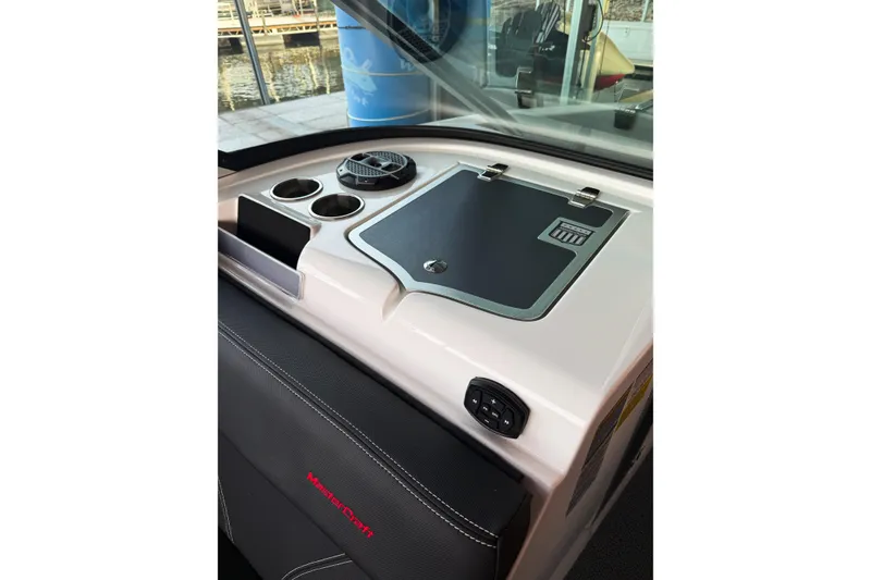 Slide: The Image of 2020 MasterCraft XT25 boat dashboard with cup holders and control panel. - 39