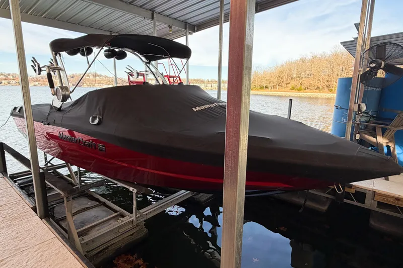 Slide: The Image of 2020 MasterCraft XT25 boat covered and docked by a serene lake. - 43