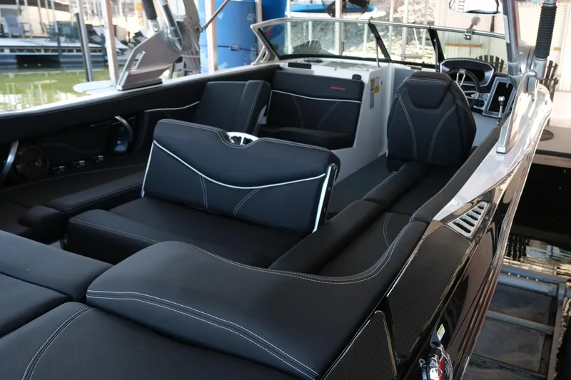Slide: The Image of 2020 MasterCraft XT25 boat interior with sleek black seating and modern design. - 7