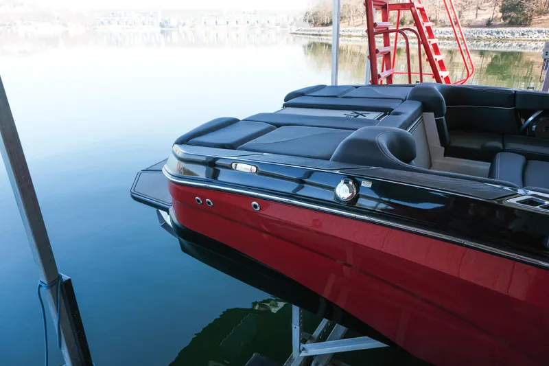 Slide: The Image of 2020 MasterCraft XT25 boat docked on calm water, showcasing sleek design and luxury seating. - 8