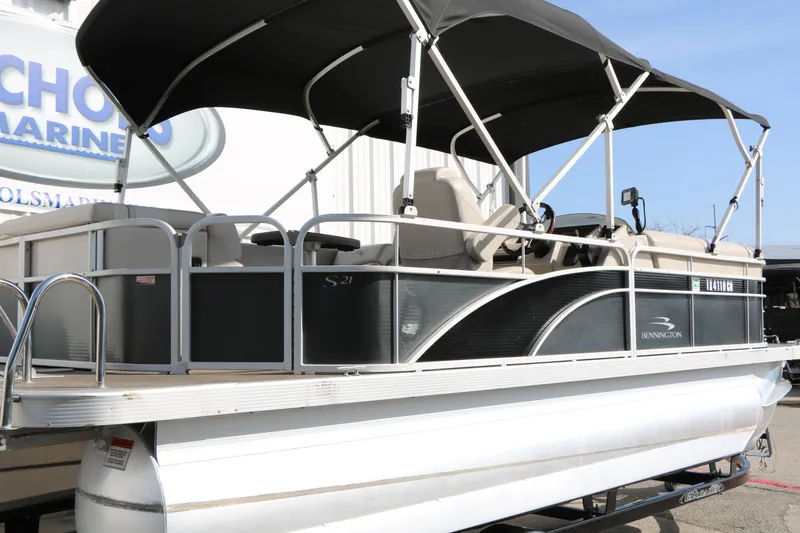 Slide: The Image of 2015 Bennington 21 SLX pontoon boat with canopy, docked at a marina. - 11