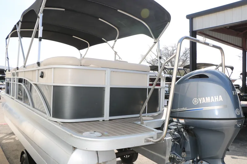 Slide: The Image of 2015 Bennington 21 SLX pontoon boat with Yamaha outboard motor, docked under a canopy. - 13