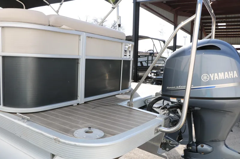 Slide: The Image of 2015 Bennington 21 SLX pontoon boat with Yamaha outboard motor, docked under shelter. - 14