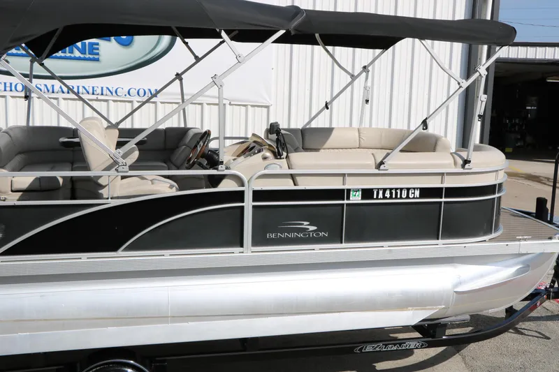 Slide: The Image of 2015 Bennington 21 SLX pontoon boat with canopy, parked on trailer. - 19