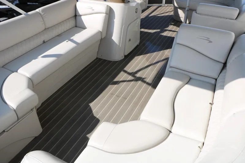 Slide: The Image of 2015 Bennington 21 SLX boat interior with white seating and wood-style flooring. - 24