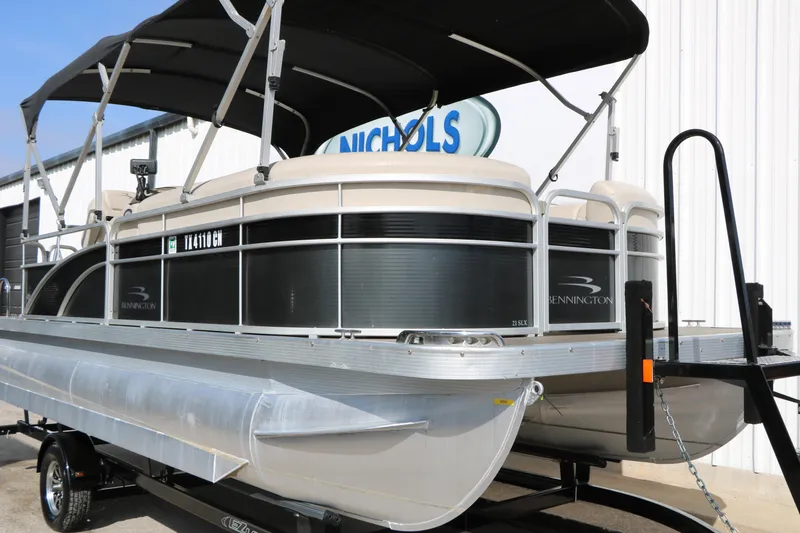 Slide: The Image of 2015 Bennington 21 SLX pontoon boat on trailer, parked outside a building. - 3