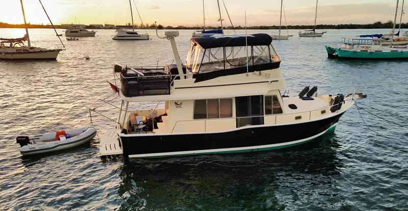 Slide: The Image of 2005 Mainship 400 Trawler on calm waters at sunset. - 1