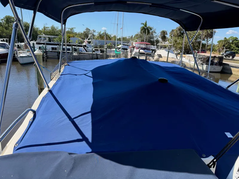 Slide: The Image of 2005 Mainship 400 Trawler with blue cover in marina. - 12