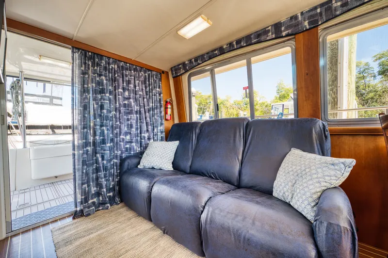 Slide: The Image of Interior of a 2005 Mainship 400 Trawler with blue couch. - 21