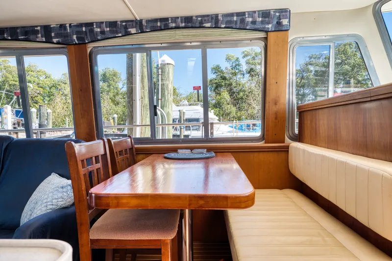 Slide: The Image of Interior of a 2005 Mainship 400 Trawler with wooden table and seating. - 22