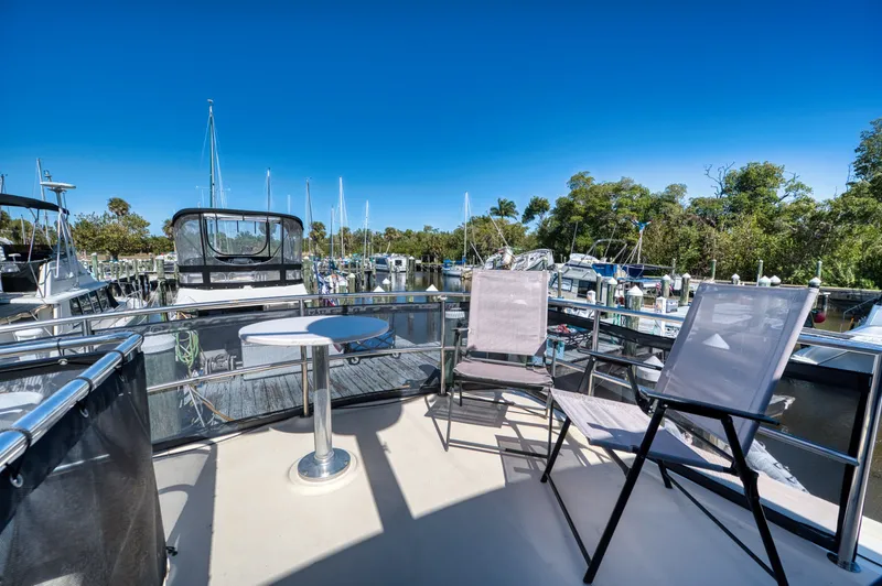 Slide: The Image of Deck of 2005 Mainship 400 Trawler with chairs and table in marina. - 38