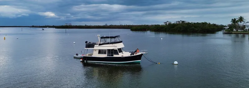 Slide: The Image of 2005 Mainship 400 Trawler on calm water under cloudy skies. - 4