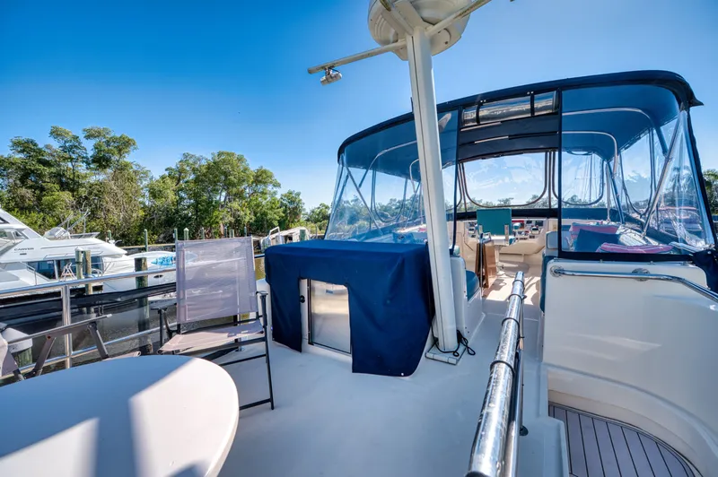 Slide: The Image of 2005 Mainship 400 Trawler with blue canopy and outdoor seating area. - 9