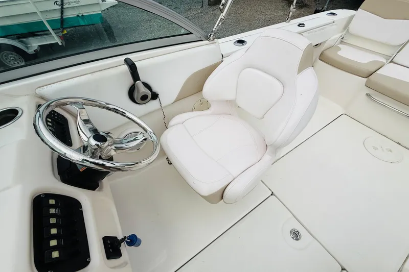 Slide: The Image of 2019 Robalo R207 Dual Console boat interior with steering wheel and white captain's chair. - 4