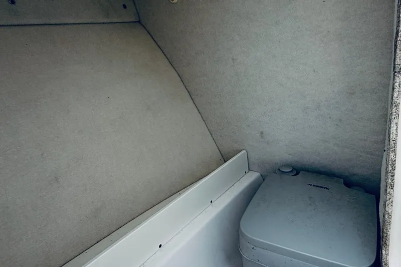 Slide: The Image of Interior of 2019 Robalo R207 Dual Console boat with portable toilet. - 8