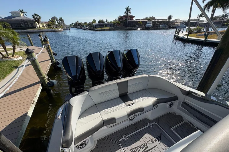 Slide: The Image of 2023 Nor-Tech 390 Sport Center Console boat docked by a scenic waterfront. - 11