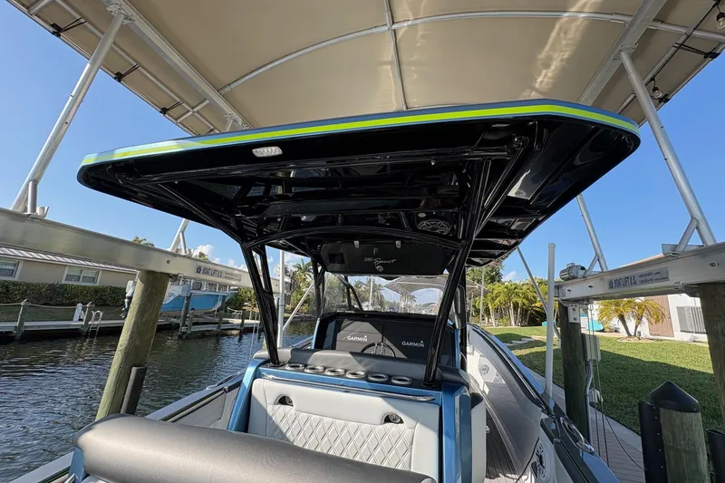 Slide: The Image of 2023 Nor-Tech 390 Sport Center Console boat docked under canopy. - 12