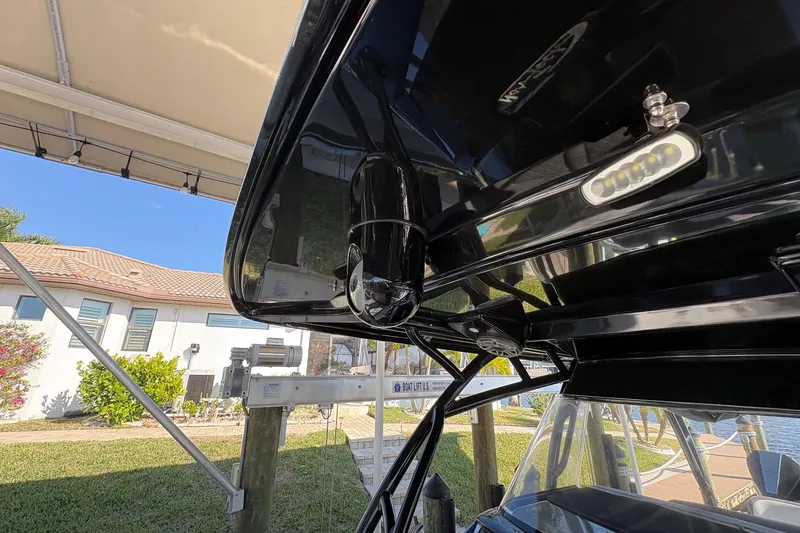Slide: The Image of 2023 Nor-Tech 390 Sport Center Console boat under canopy, showcasing sleek design and lighting. - 15