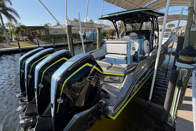 Slide: The Image of 2023 Nor-Tech 390 Sport Center Console boat docked with multiple outboard engines. - 4