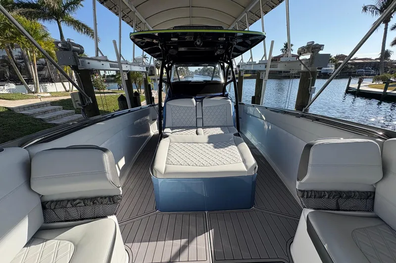 Slide: The Image of 2023 Nor-Tech 390 Sport Center Console boat interior with luxurious seating and waterfront view. - 6