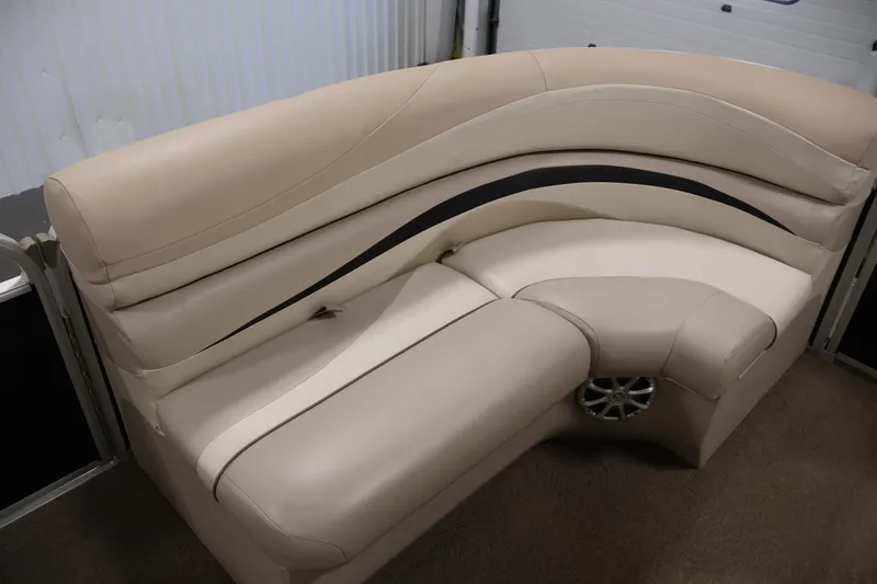 Slide: The Image of 2012 Bennington 2275 GCW boat interior with beige seating and integrated speaker. - 13