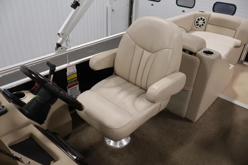 Slide: The Image of 2012 Bennington 2275 GCW boat interior with beige captain's chair and steering wheel. - 32