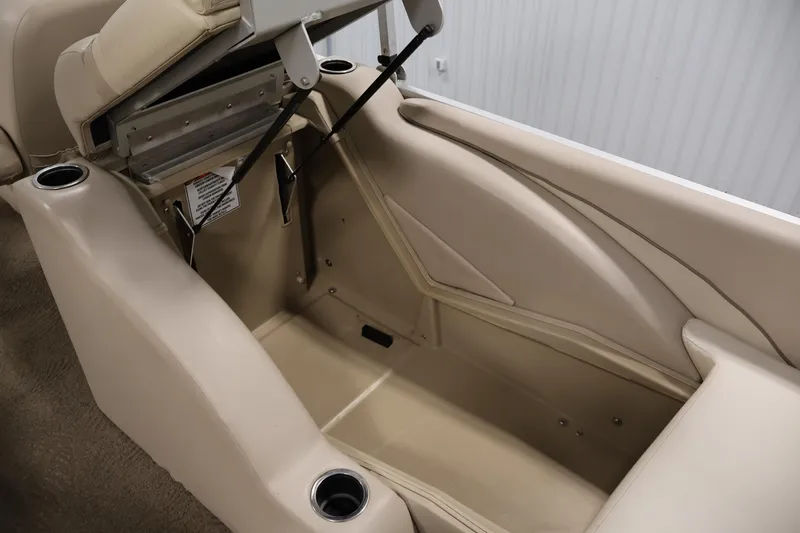 Slide: The Image of 2012 Bennington 2275 GCW boat interior storage compartment with beige upholstery and cup holders. - 37