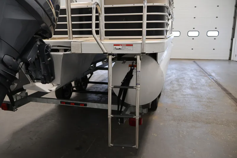 Slide: The Image of 2012 Bennington 2275 GCW pontoon boat rear view with motor and ladder in garage. - 39