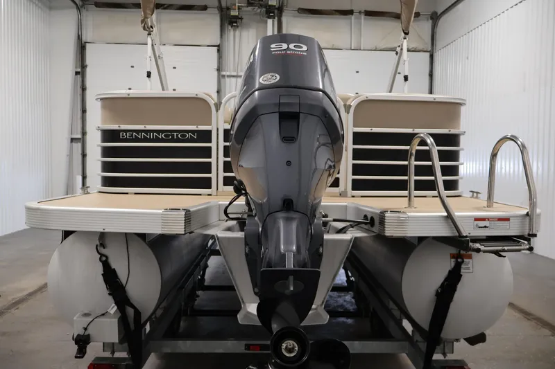 Slide: The Image of 2012 Bennington 2275 GCW pontoon boat with 90 HP outboard motor in a garage. - 6