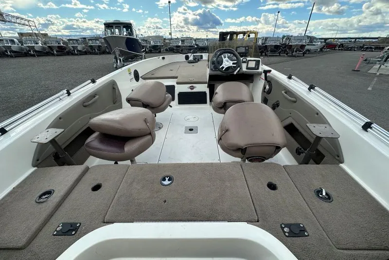 Slide: The Image of 2008 Ranger 1760 Angler boat interior with seating and steering wheel, parked outdoors. - 4
