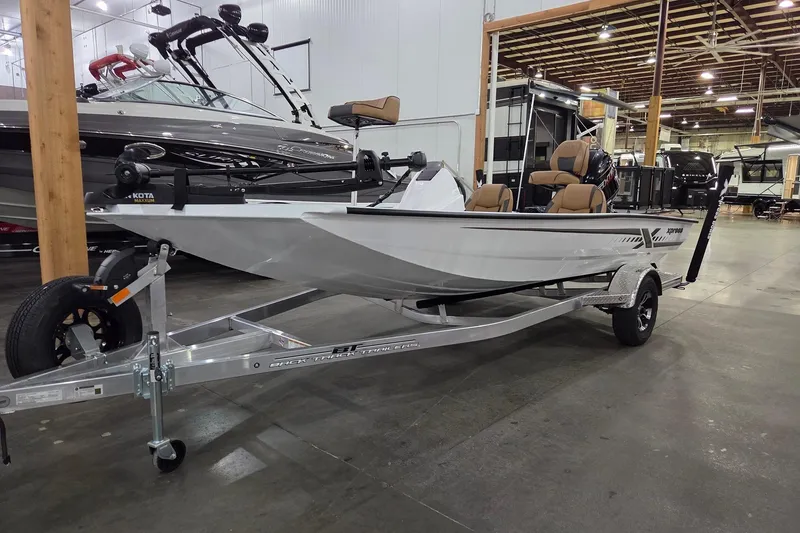 Slide: The Image of 2026 Xpress H18 boat on trailer in showroom, featuring sleek design and modern seating. - 0