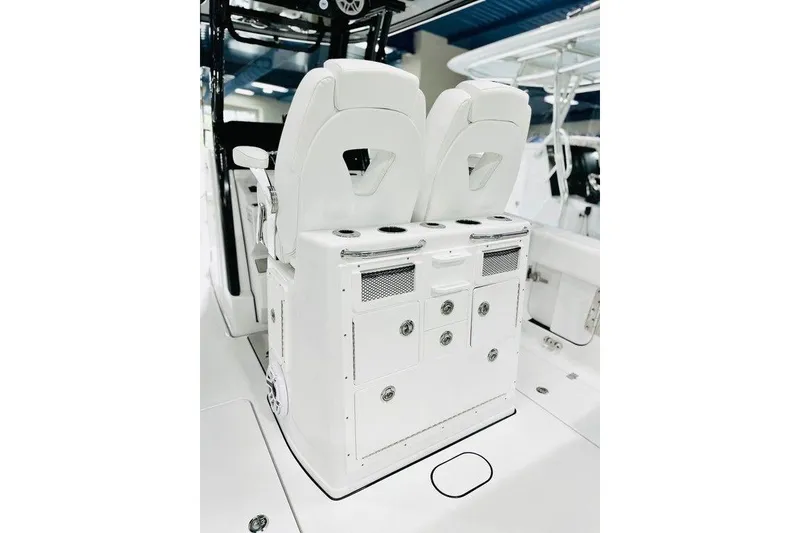 Slide: The Image of 2026 Sportsman Open 262 Center Console boat interior with dual white seats and storage compartments. - 5