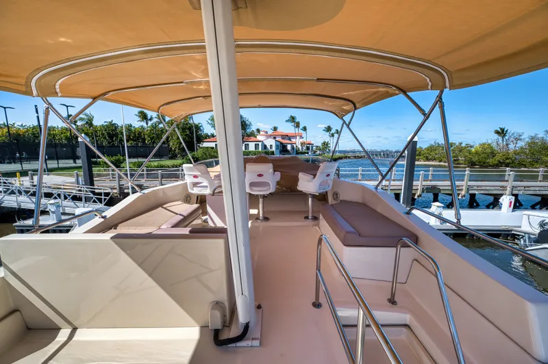 Slide: The Image of 2006 Mainship 34 Trawler with covered deck and seating area by the water. - 11