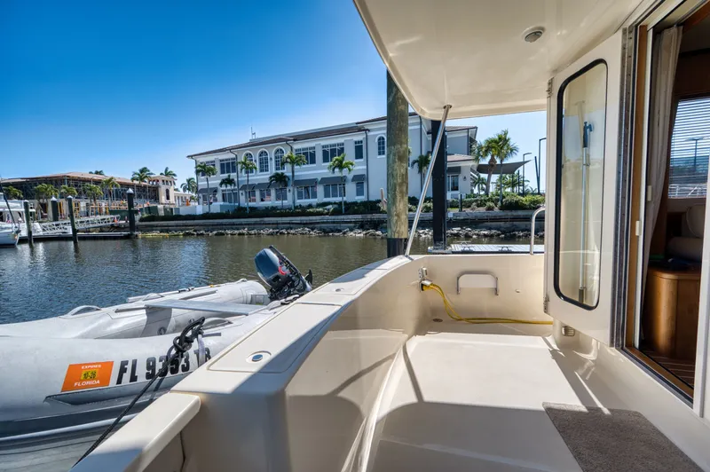 Slide: The Image of 2006 Mainship 34 Trawler docked with dinghy and waterfront view. - 13