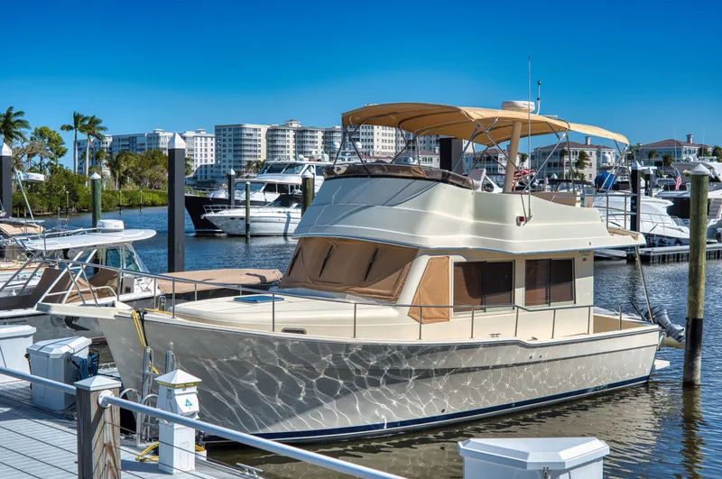 Slide: The Image of 2006 Mainship 34 Trawler docked at marina on a sunny day. - 2