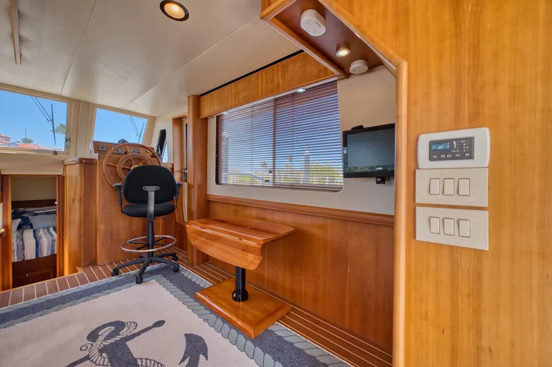 Slide: The Image of Interior of 2006 Mainship 34 Trawler with helm and wood finish. - 25