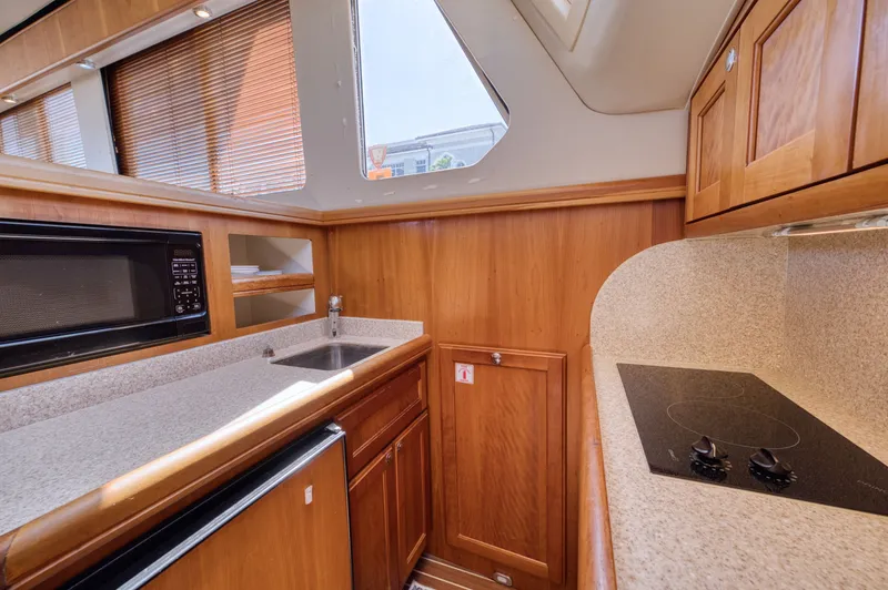 Slide: The Image of Interior of 2006 Mainship 34 Trawler with kitchen and wood paneling. - 33