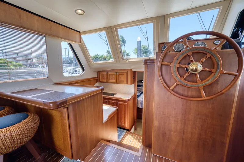 Slide: The Image of Interior of a 2006 Mainship 34 Trawler with wood paneling and steering wheel. - 37